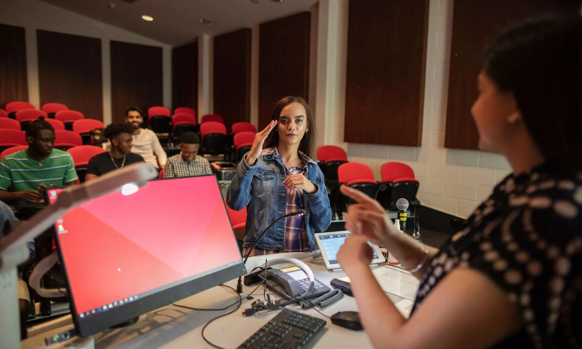 A classroom demonstration of the American Sign Language sign for “deaf”.