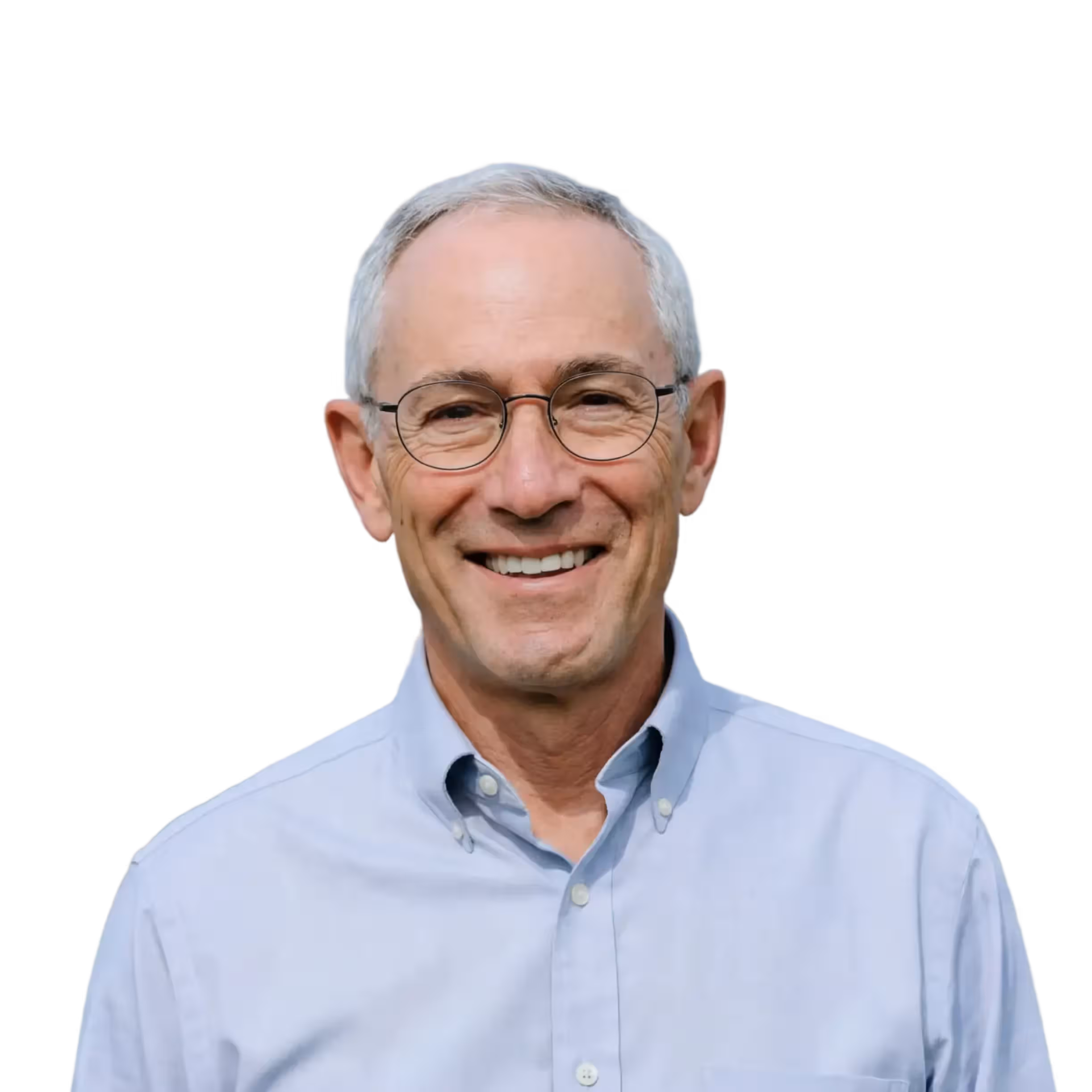Smiling middle-aged man with short gray hair wearing round glasses and a light blue shirt.
